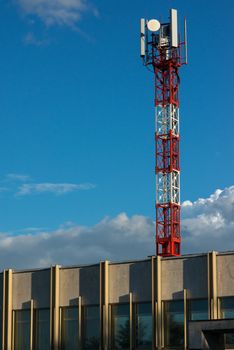 Red and white antenna tower on the roof of the building.