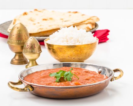 East Indian meal consisting of butter chicken, rice and nan bread.