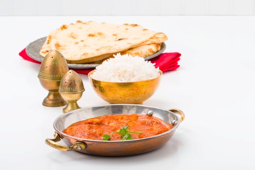 East Indian table setting with butter chicken and rice.