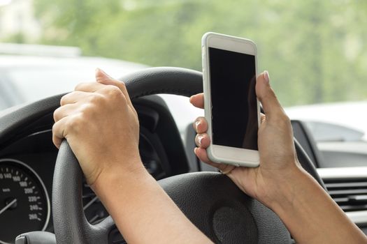 girl with a mobile phone behind the wheel in the saloon car