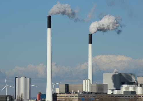 Factory chimneys with clouds and small windmills