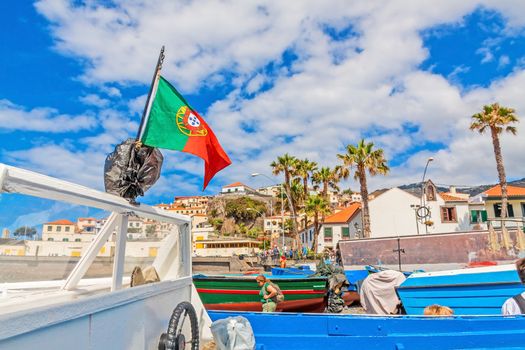 Camara de Lobos, Madeira - June 8, 2013: At the harbor of Camara de Lobos - motorboat with flag of Portugal in the foreground.