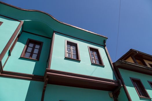 Close up bottom view of historical old colorful Odunpazari houses on bright blue sky background.
