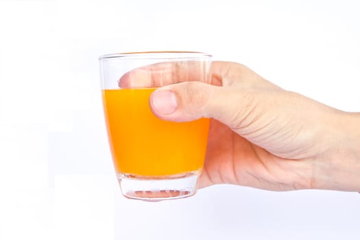 Male hand holding an orange juice glass. 