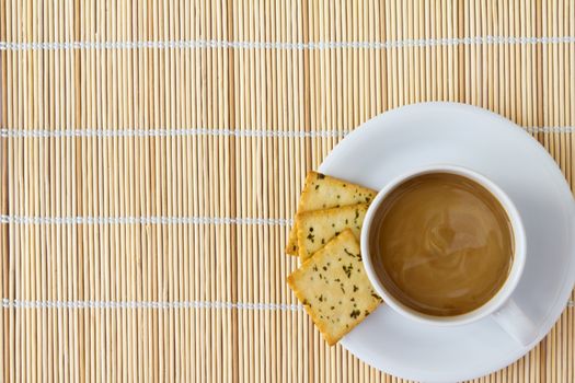 Coffee. White porcelain cup and three biscuit on a mat 