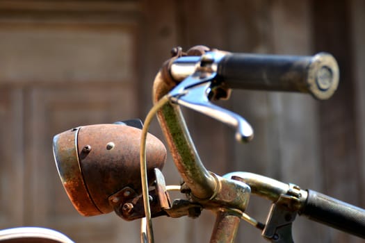 Vintage bicycle detail close up with wood Background.