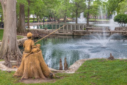 STILLWATER, OK/USA - MAY 20, 2016: Boy and Dog Fishing Sculpture at Theta Pond on the campus of Oklahoma State University.