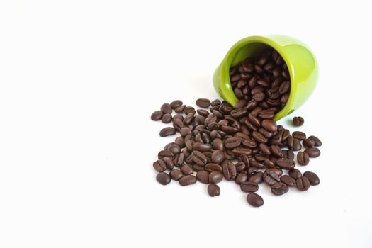 Coffee beans in green cup on white background