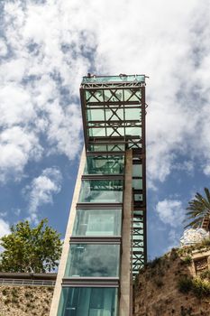 Bottom view of lift with glass observation terrace in Antalya Kaleici on cloudy blue sky background.