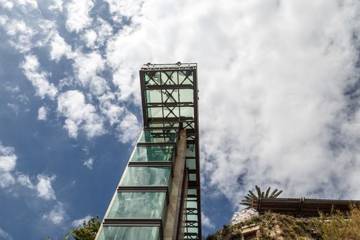 Bottom view of lift with glass observation terrace in Antalya Kaleici on cloudy blue sky background.