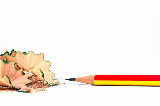 Pencil with sharpening shavings on white background 