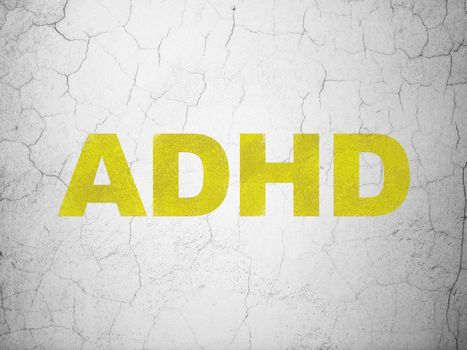 Health concept: Yellow ADHD on textured concrete wall background