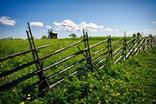 Green lanscape with one old windmill and blue sky, Russia