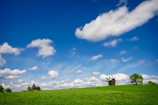 Green lanscape with one old windmill and blue sky, Russia