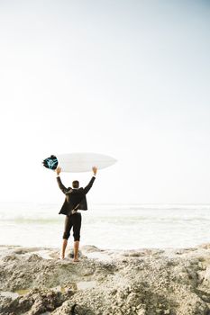 A Businessman holding is surfboard after a long day of work