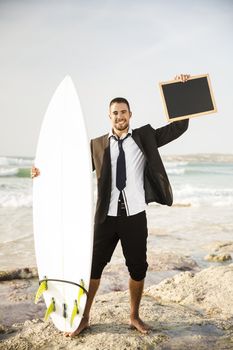 Businessman holding a chalkboard and is surfboard. Concept about a man starting a new life.