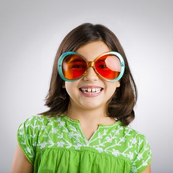 Portrait of a happy young girl wearing funny sunglasses