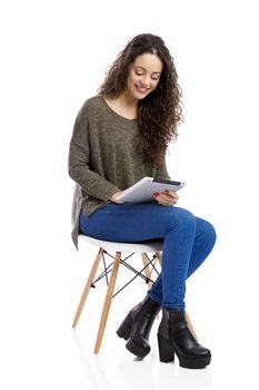 Beautiful and happy woman working with a tablet, isolated over white background 