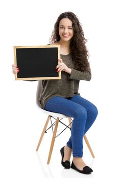 Beautiful and happy woman showing something on a chalkboard