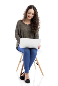 Beautiful and happy woman working with a laptop, isolated over white background 