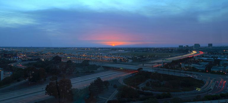 Irvine, California, February 26, 2016: Aerial view of John Wayne Airport in Orange County, California, at sunrise with light trails across the 405 highway in front.