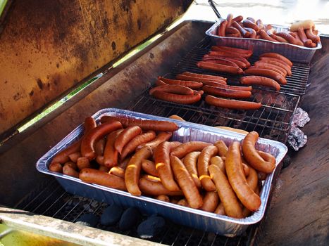 Grilling selection of sausages on a cast iron BBQ barbecue grill