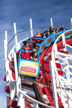 Santa Cruz, California, USA-November 15, 2014 : People on Giant Dipper the fifth oldest wooden coaster in the US. Built by Arthur Looff in 1924 and maximum speed is up to 46 mph. Taken in Santa Cruz Beach Boardwalk`s Park.