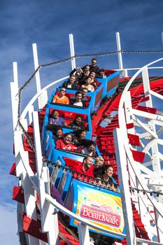 Santa Cruz, California, USA-November 15, 2014 : People on Giant Dipper the fifth oldest wooden coaster in the US. Built by Arthur Looff in 1924 and maximum speed is up to 46 mph. Taken in Santa Cruz Beach Boardwalk`s Park.