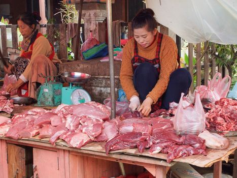 LUANG PRABANG, LAOS - FEBRUARY 13, 2016: People on the morning open air market of Luang Prabang on February 13, 2016 in Laos, Asia