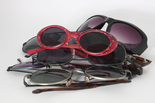 Pile of sunglasses with red pair on top - isolated