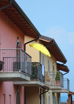Yellow parasol on balcony with colorful house