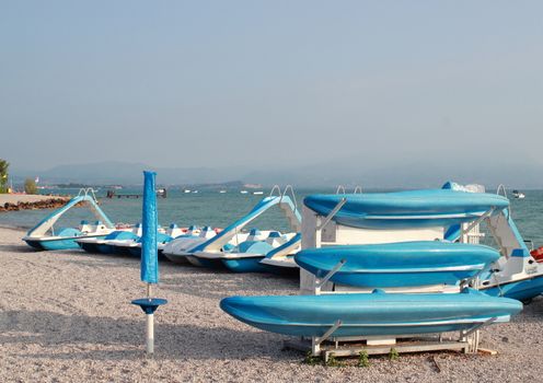 Blue boats and water cycles at rubble beach in the morning