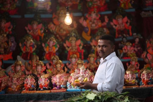 Pune, India - September 16, 2015: A man selling Lord Ganesh idols on the eve of Ganesh festival in India. The festival involves thousands of visitors from all over the world every year, in the main celebration city - Pune. 