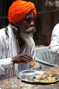 Pune, India  - ‎July 11, ‎2015: A hindu pilgrim having a meal served to him by a charitable organization, during the Wari festival in India.