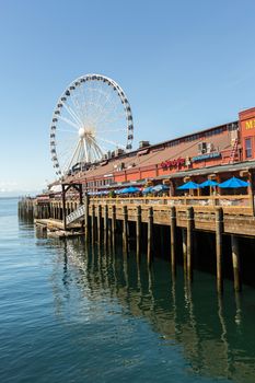 SEATTLE, WA - MAY 12: Businesses with ferris wheel in background on Seattle’s waterfront. May 12, 2016 in Phoenix, AZ.