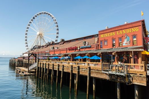 SEATTLE, WA - MAY 12: Businesses and ferris wheel on Seattle’s waterfront. May 12, 2016 in Phoenix, AZ.