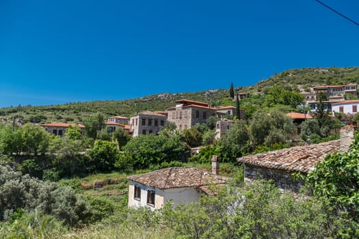 Landscape view of historical Doganbeyli village in Aydin, Turkey with historical small stone houses on bright blue sky background.