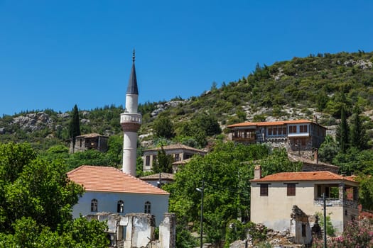 Landscape view of historical Doganbeyli village in Aydin, Turkey with historical small stone houses on bright blue sky background.