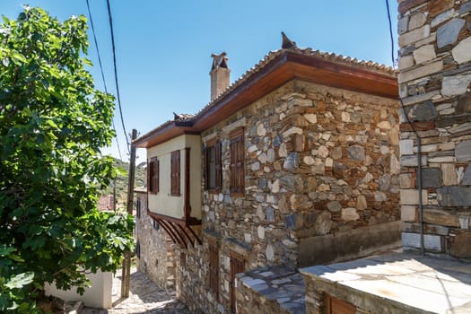 Landscape view of historical Doganbeyli village in Aydin, Turkey with historical small stone houses on bright blue sky background.