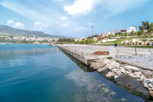 Close up view of Gerze port along Black Sea with high mountains and smal houses on cloudy blue sky background.