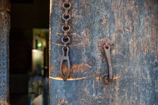 Close up front view of wooden old door, with historical rusty padlock.