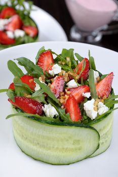 portion of strawberry salad with arugula and ricotta in cucumber