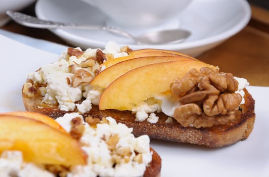Sandwich of oat bread with ricotta and slices of peach,  nuts, watering honey