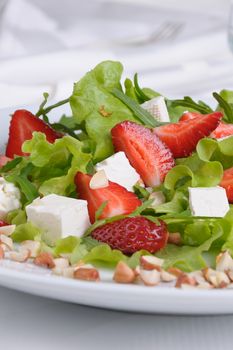 Salad of lettuce, arugula, strawberries, feta cheese and peanuts