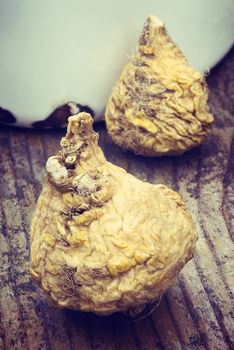 Peruvian ginseng or maca (Lepidium meyenii), dried root on wooden table