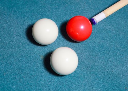 Carambole billiards with cue on blue cloth