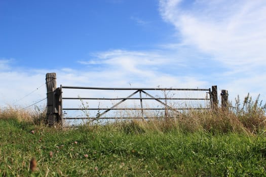 Field gate on top of a hill with blue sky