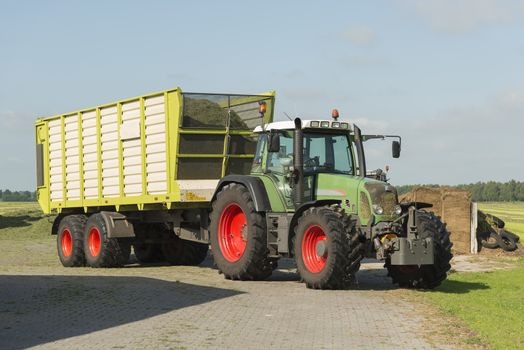 transport of cut grass with tractor and loader wagon in the summer