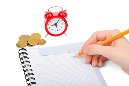 Hand writing in notebook with coins and alarm clock on isolated white background