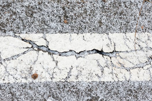 Crack on asphalt under snow in winter
